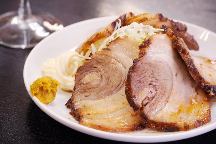 人気のチャーシュー580円。皮目が香ばしい。肉汁と旨味たっぷりのタレで千切りキャベツがいくらでも食べられる。