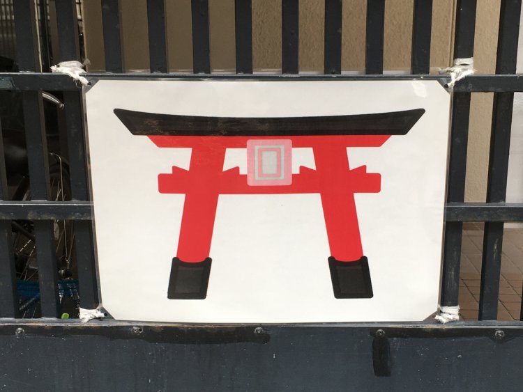 駐車場に掲げられた鳥居の絵。これだけで全てを理解してもらえるだろうか（田端）