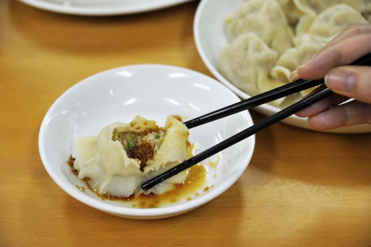 水餃子は、ニンニクの香りが食欲を誘う特製タレにつけて味わう。