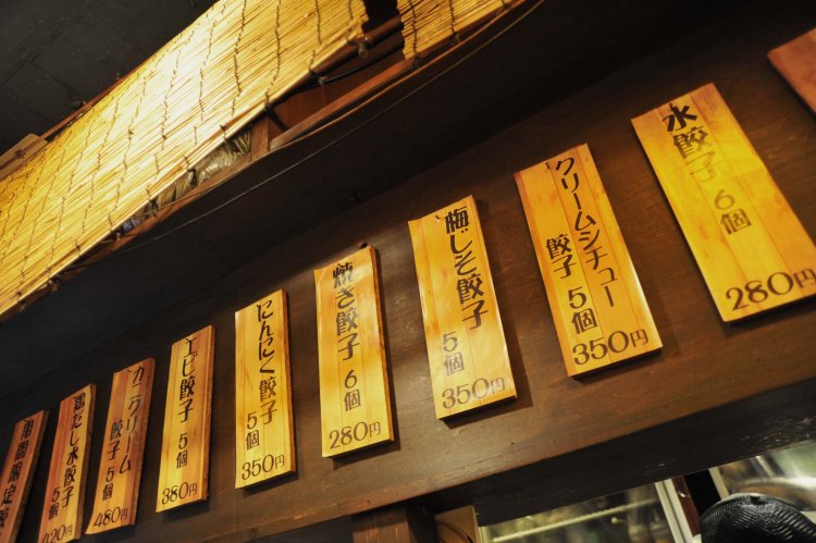 カウンター上の壁を見れば、クリームシチューやカニクリームなど、餃子とは思えないようなメニューが掲げられている。