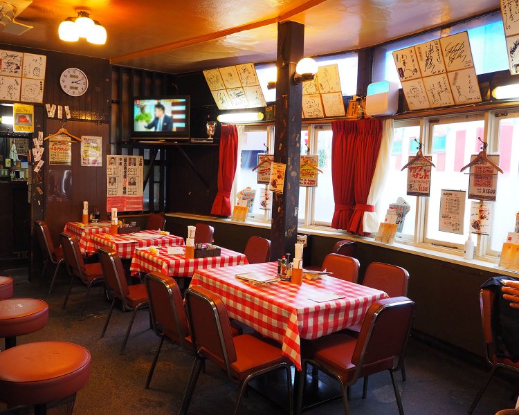 著名人のサインが飾られた店内。チェック柄のテーブルクロスもたまらない。