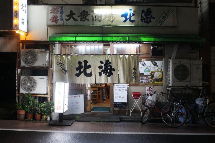 白のれんには三四郎の文字。店名の“三四郎”は店主が小説「姿三四郎」のモデルとなった明治の柔道家、西郷四郎氏の子孫であることから名付けられた。