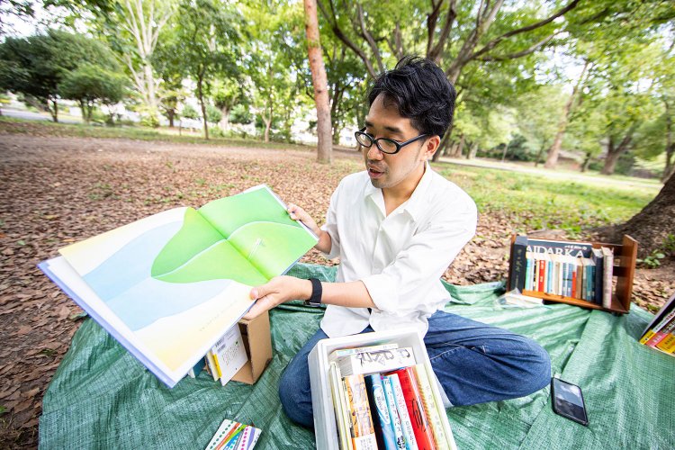 絵本『よあけ』（ユリー・シュルヴィッツ/福音館書店）を広げ、「最後のこのページがいい！」と魅力を伝える筆者。