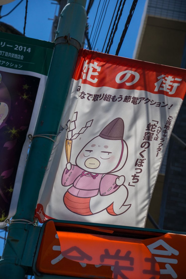 「蛇の街」のゆるキャラがはためく。これで商店街に長蛇の列ができれば完璧に蛇の街だ。