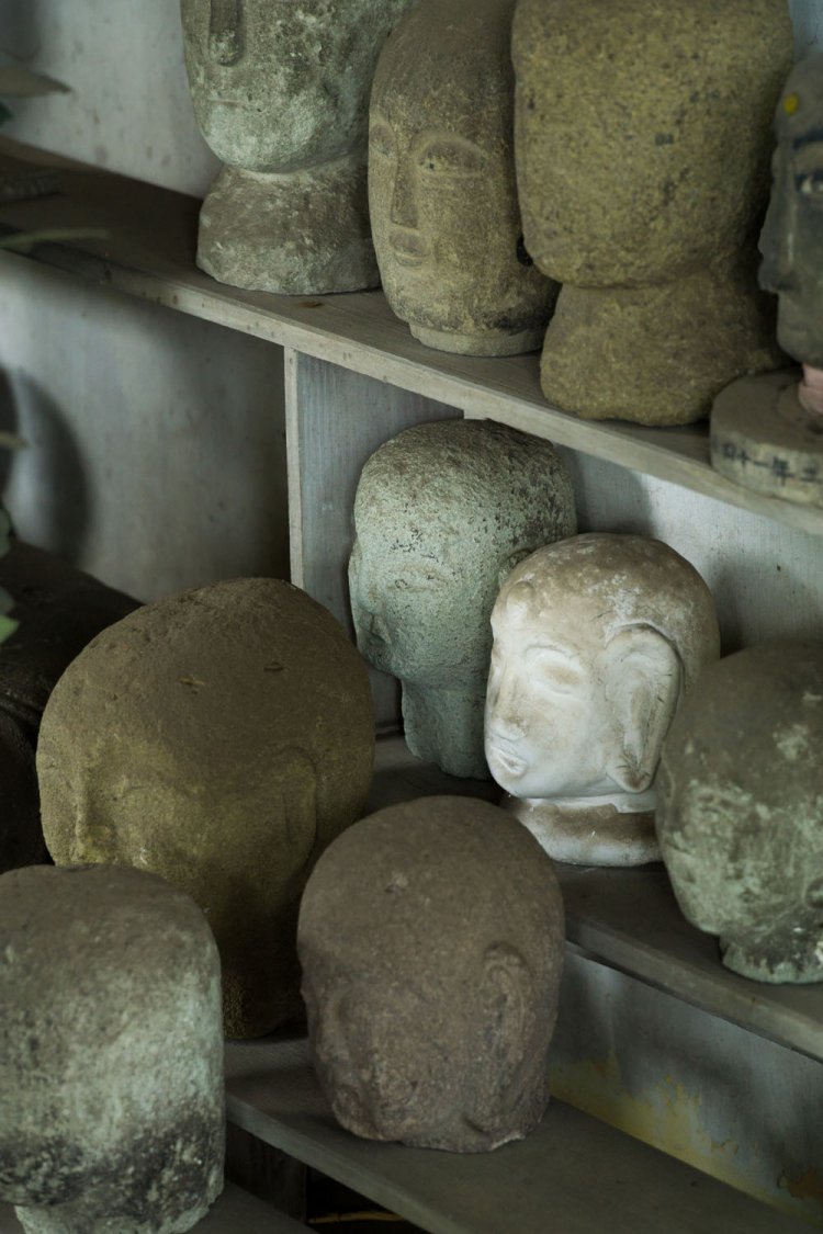 お地蔵さまのまわりにたくさんの首が並ぶ。願いを叶えるごとに首が増えていく。いつからなぜこうするようになったかは不明。