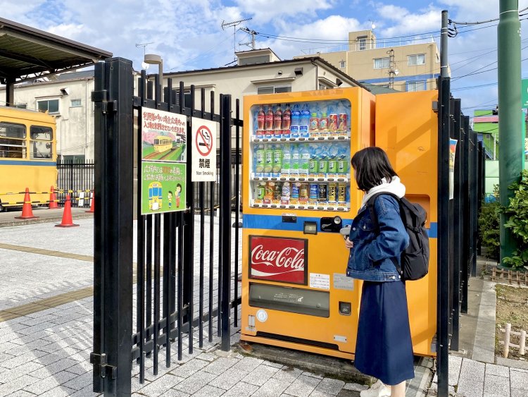 「都電おもいで広場」前のカワイイ自販機。左奥に見えるのが「学園号」（旧7500形）。