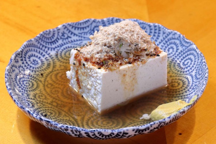 豆腐は木綿豆腐で半丁分の大きさ。仕上げに少量の醤油をかける。