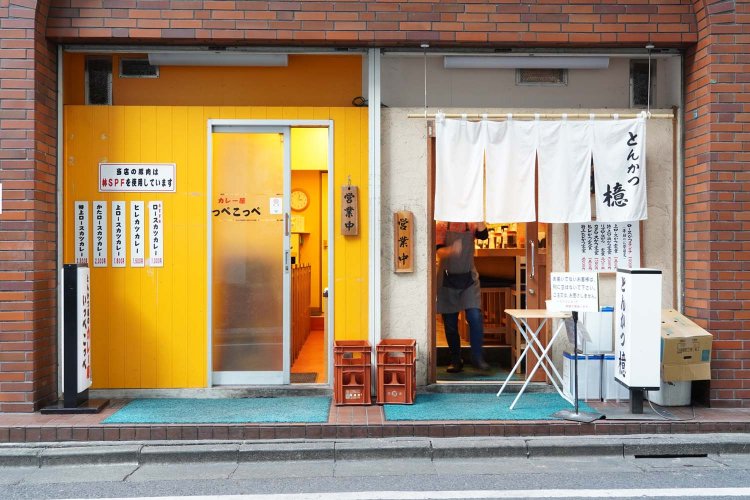 とんかつ屋と並んでカレー屋の入り口がある。どちらもカウンターのみのこぢんまりとした造りで、開店とともに行列ができる。