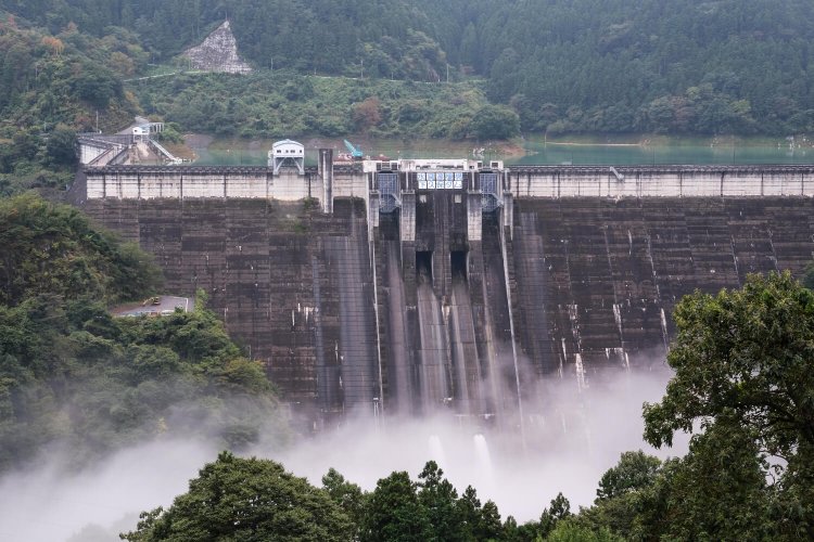 水煙が立ち昇る放流中の下久保ダム。手前が主ダムで左が補助ダム。
