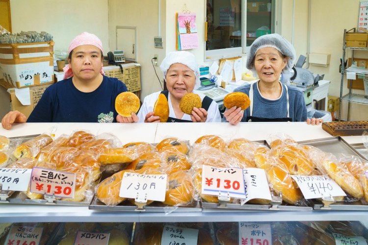佐藤さん一家が手にしているのは、右から、牛すじ黒カレー150円、特製カレーパン、辛口カレー130円、角切り野菜のカレーパン130円。