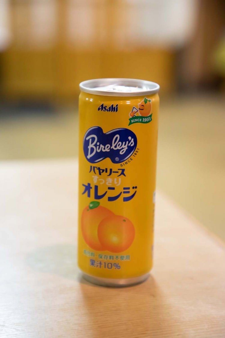 小学生以下の子供にサービスしているジュース缶。