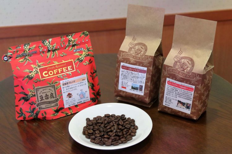 マスコット「マメおじさん」が描かれた豆袋にはコーヒー豆から発生するガスを外へ出す工夫がしてある。左はドリップパック。
