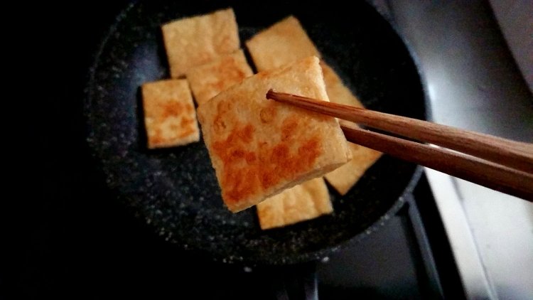 油揚げを箸で持っている