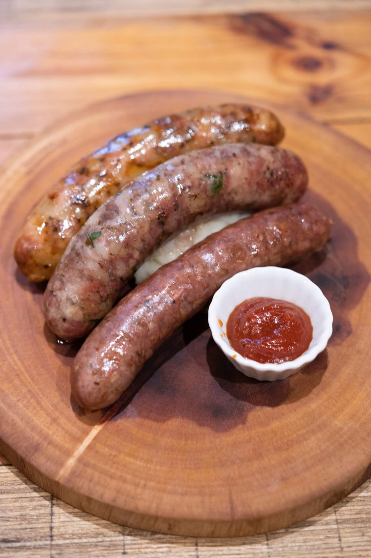 自家製ソーセージは日替わりで常時8～10種。手前からイタリアのサルシッチャ、モロッコのメルゲーズ、豚トロ入りTHEオリジナル各680円。オリオンビールと相性抜群だ。