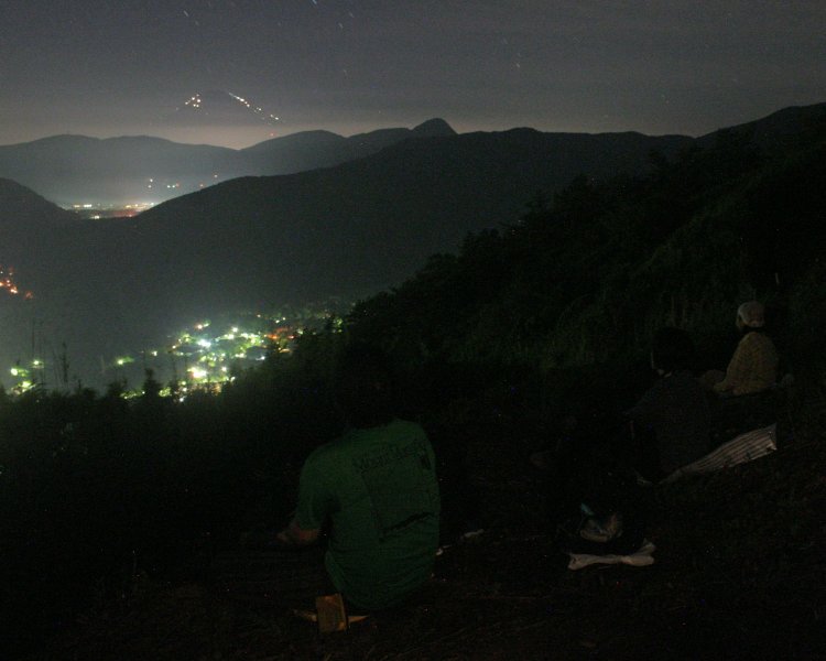 箱根の明星ヶ岳からヒカリフジを望む。富士山が登山者のヘッドランプと山小屋の灯りに縁取られている。