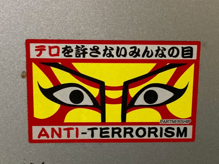 地下鉄のゴミ箱の上に貼られたテロ防止の隈取ステッカー。隈取のデザインが他と異なる（西早稲田・2021年）