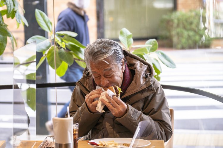 ハンバーガーをガブり。「僕の好きな、たまごかけごはんよりうまいよ」。
