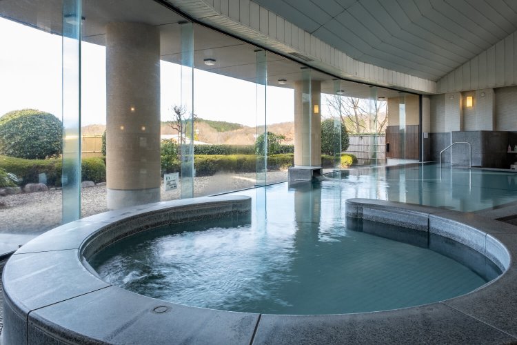 ゆるやかなカーブを描いた内湯は全面ガラス張りで明るく、ゆったりとした造りだ。