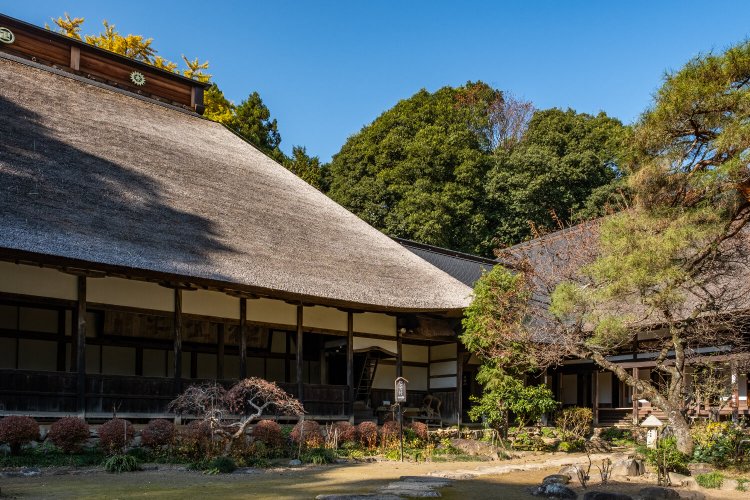 本尊の釈迦如来坐像を祀る重厚な本堂（左）と庫裡（右）。