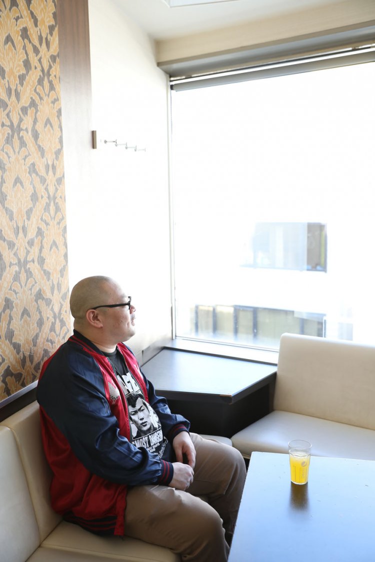 思い出のカラオケ店から街を眺める爪さん。