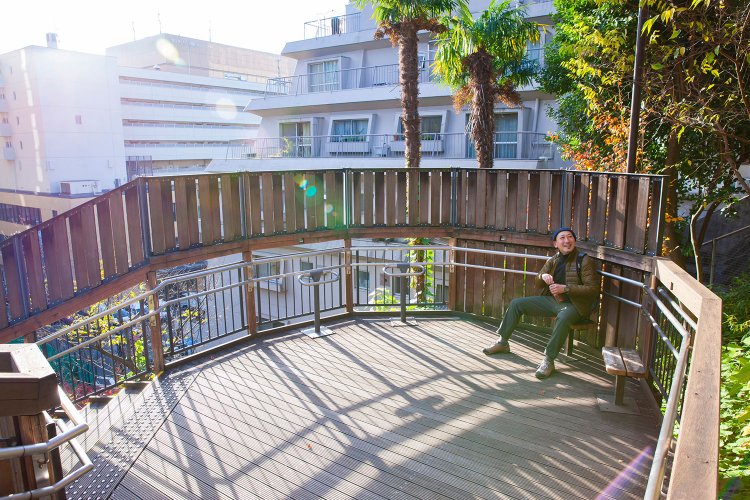 長い階段だけにウッドデッキの踊り場にはスツール、頂上にはベンチが。港区のビル群を眺め、小休止できる。