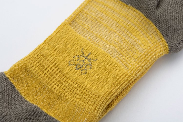 底面には「楽」のワンポイント。奈良県の高機能靴下ブランドのトレードマークだ。