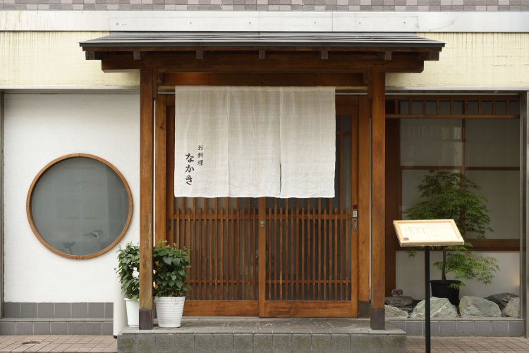 繁華街の一角に暖簾（のれん）を下げて営業中。