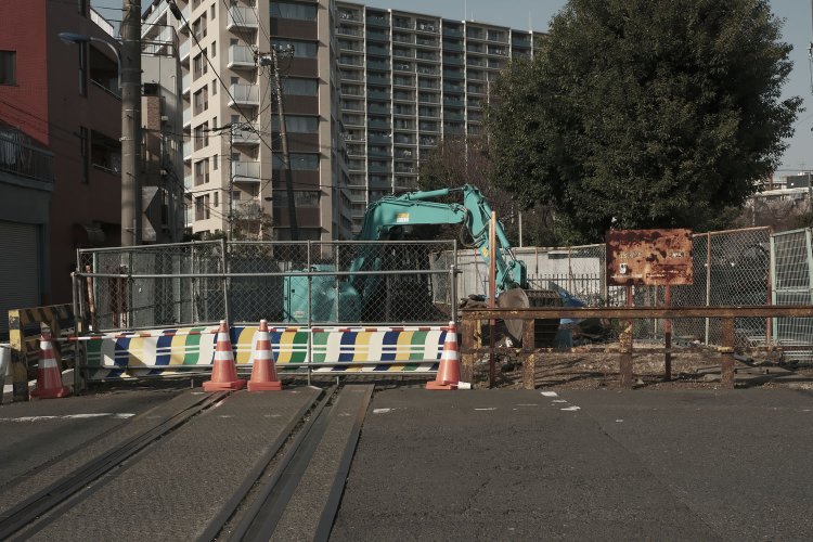 同じ踏切の北方向。重機は踏切設備を解体していると思われる。背後は再開発によって誕生したマンション群だ。