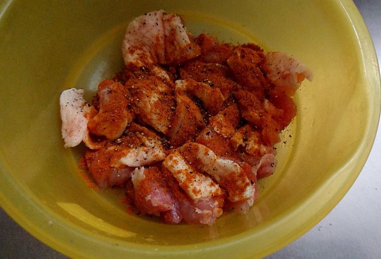 ボウルに鶏もも肉とスパイスを入れる