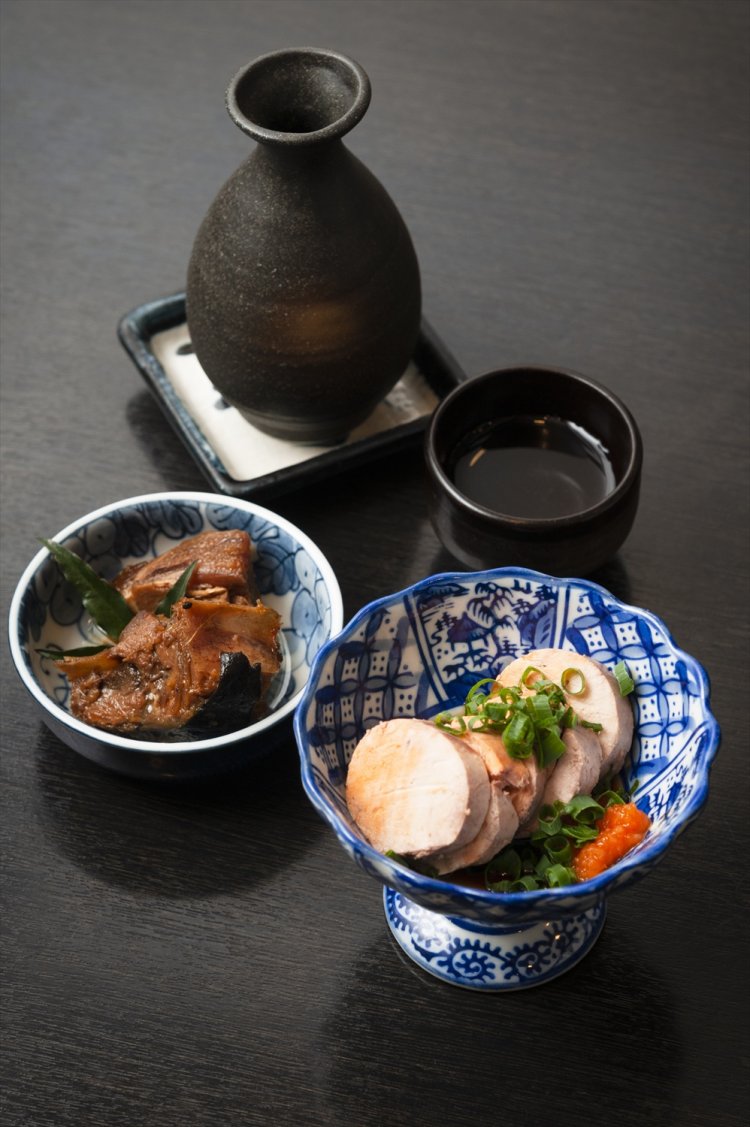 あん肝500円（手前）。日本酒は1合600円～。お酒を頼むと、上島さんお手製の日替わり小鉢もついてくる。