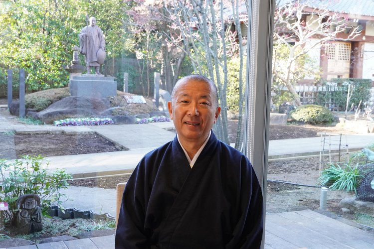 穏やかな表情の野々部住職。後ろには弘法大師の像が見える。