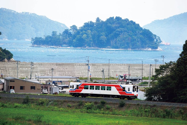 湖のように波静かな山田湾の前を走る。中央にはオランダ島が浮かぶ。陸中山田～織笠間。