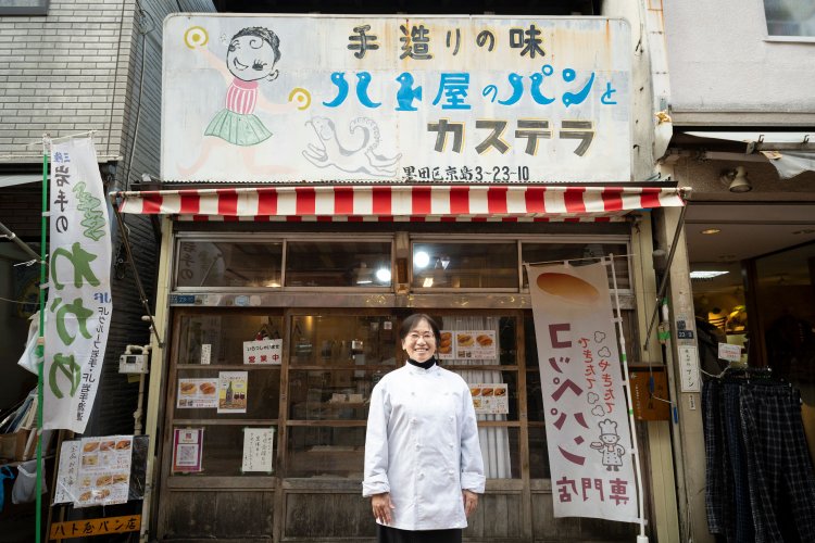 店に立つ紙田さん。色あせた看板も塗り直して使っている。