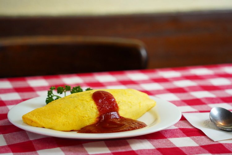 明治誕生オムライス。卵とご飯が混ざった元祖オムライスと違って、こちらは挽肉入りの炒めご飯を卵で包んだ、オーソドックスなスタイルだ。