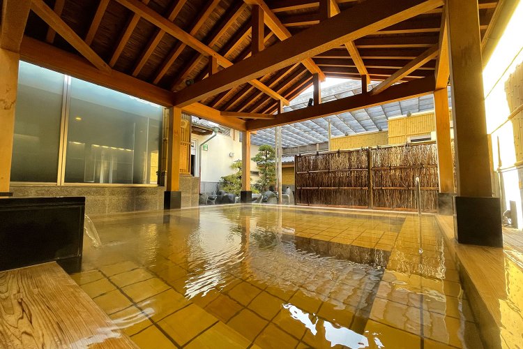 無色透明の湯が浴槽に注がれ空気に触れると琥珀色に変わる。写真は女性用露天風呂の「桜王の湯」。