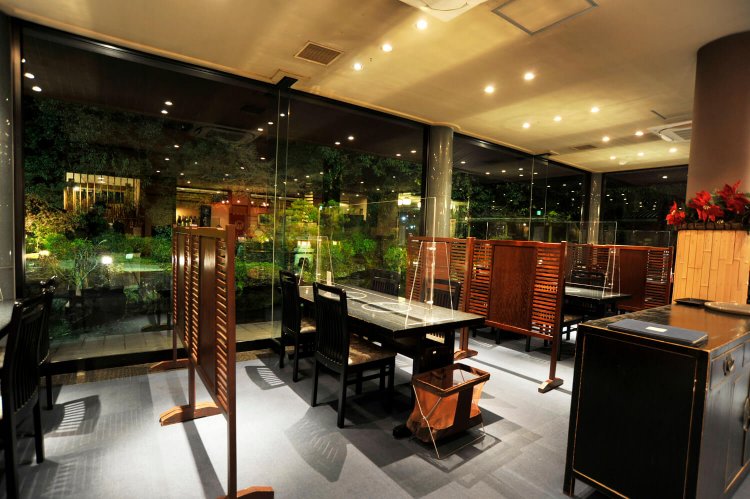 庭園を眺めるテーブル席。店内も高級感がある。