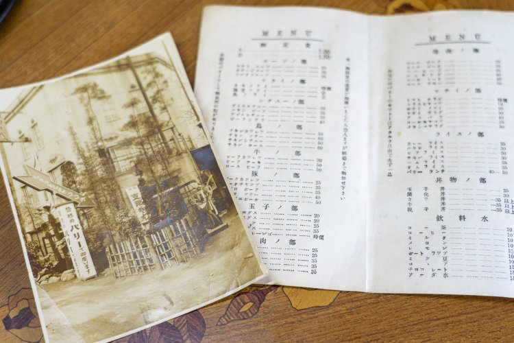 創業当時の写真とメニュー。「オムライス　35銭」の文字が見える。