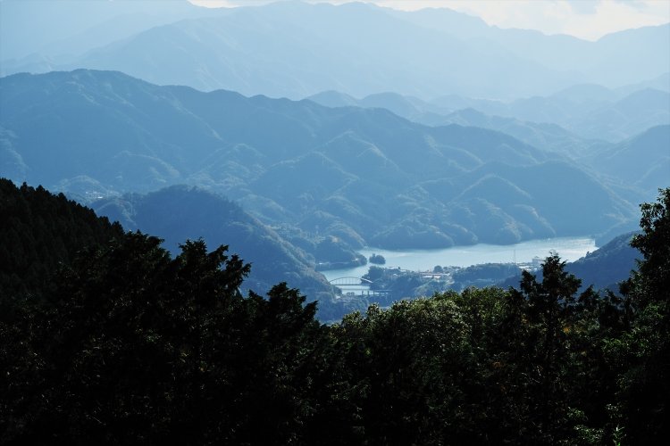 景信山の展望台から相模湖を見下ろす。山に囲まれたダム湖には、小さな島や橋も見える。
