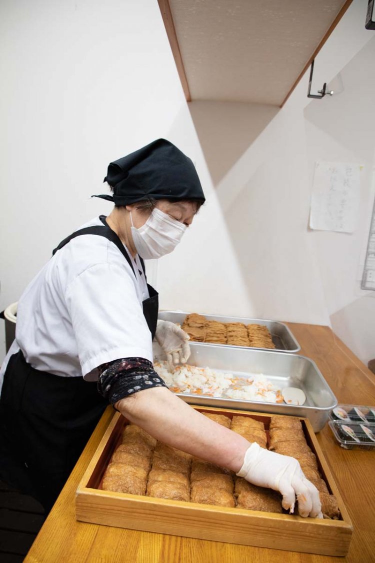 木箱に隙間なく黄金色のいなり寿司とのり巻きを詰めていく。