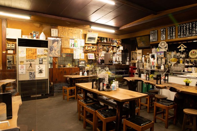 自粛期間中でついたてがあるが、普段は相席。他人同士が肩を並べる