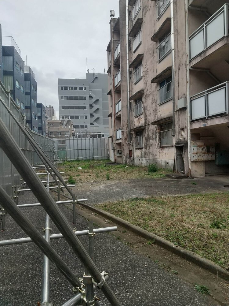 透明板から覗いた21号棟。周囲のビル群とのギャップが……。