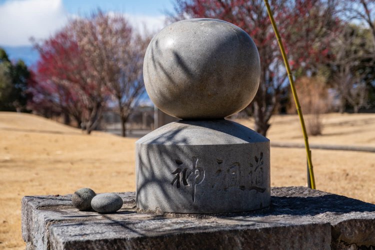 庭の一角にある丸石道祖神は甲府市上石田でかつて祀られていたもの。