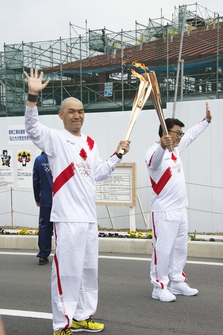 次のランナーへ炎の引き継ぎ、トーチキス。