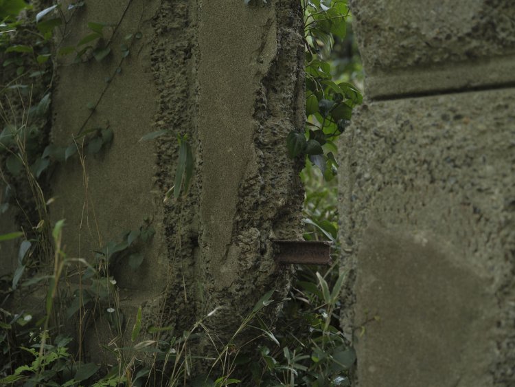 門柱の一部が壊れてトロッコレールが顔を出している。