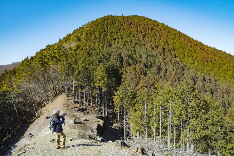 視界が開けた送電線跡地から、露天採掘地や里の風景が見渡せる。