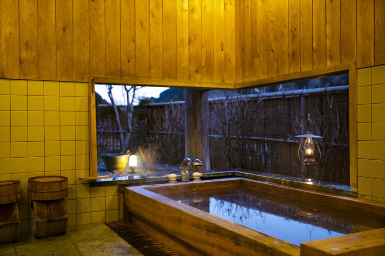 ヒノキ風呂。石灰質の井戸水を薪で沸かし、肌になじむよう。空と山を眺められる。
