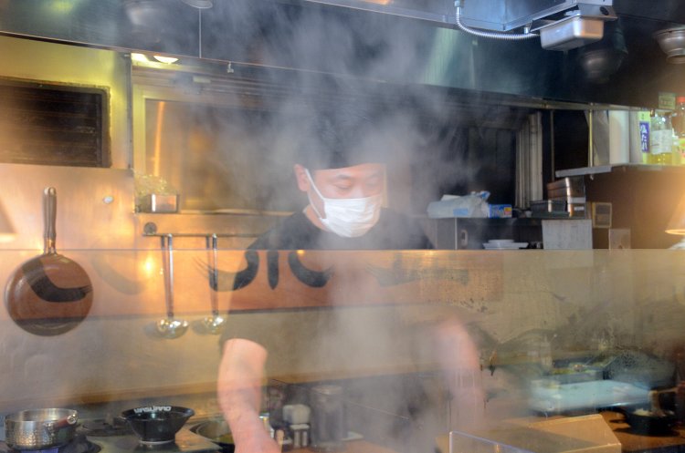 厨房内でラーメン作りに励む小島さん。もうもうと湧く湯気が食欲をそそる。