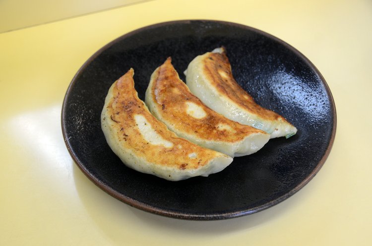 ラーメンとともに人気の餃子（写真は半餃子300円）。かなりのビッグサイズだが、アンの中身は野菜が中心でさわやかな味わいに。