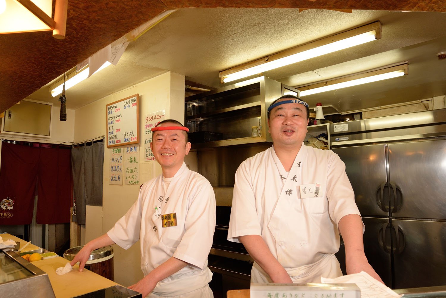 馬道店に35年という店長の増元裕之さん（右）とイナセな千葉勇さん。「バクダンも旨いっすよ」。バクダン990円はウニ、イクラなどを混ぜて味わう。