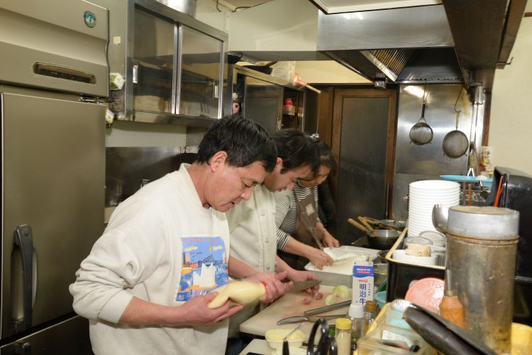 河野謙二さん・初江さん夫婦と息子の貴和さん。出前の注文も多く、チームワークは抜群。「家族でがんばってます」。